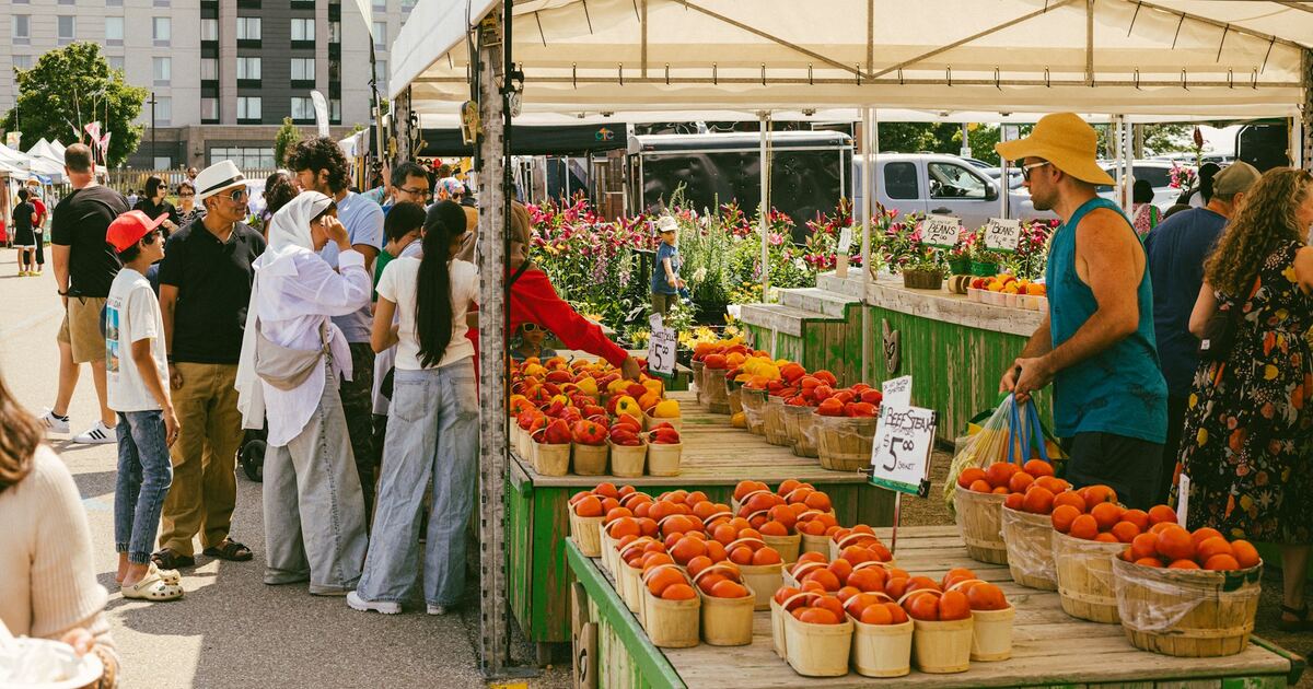 A busy farmers market scene with people trading handmade goods and produce