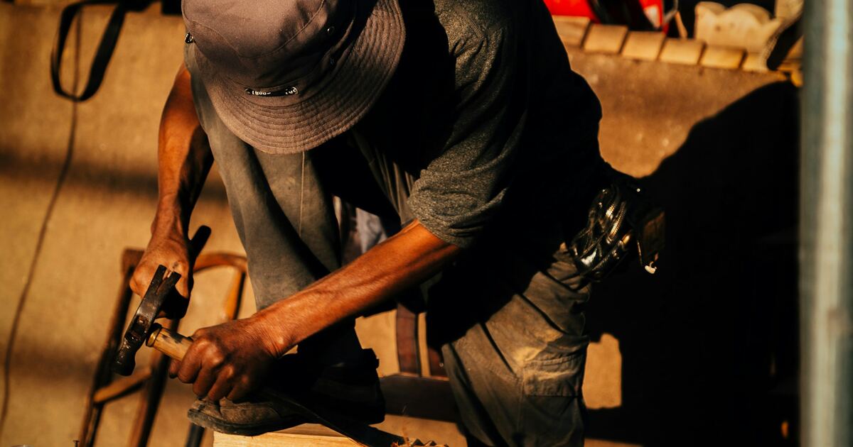 A workbench with tools and a laptop, representing skilled hands-on work
