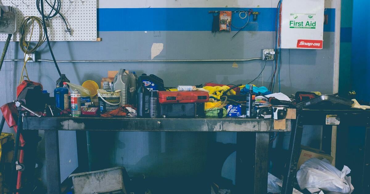 A garage with various tools, camping gear, and household items organized on shelves